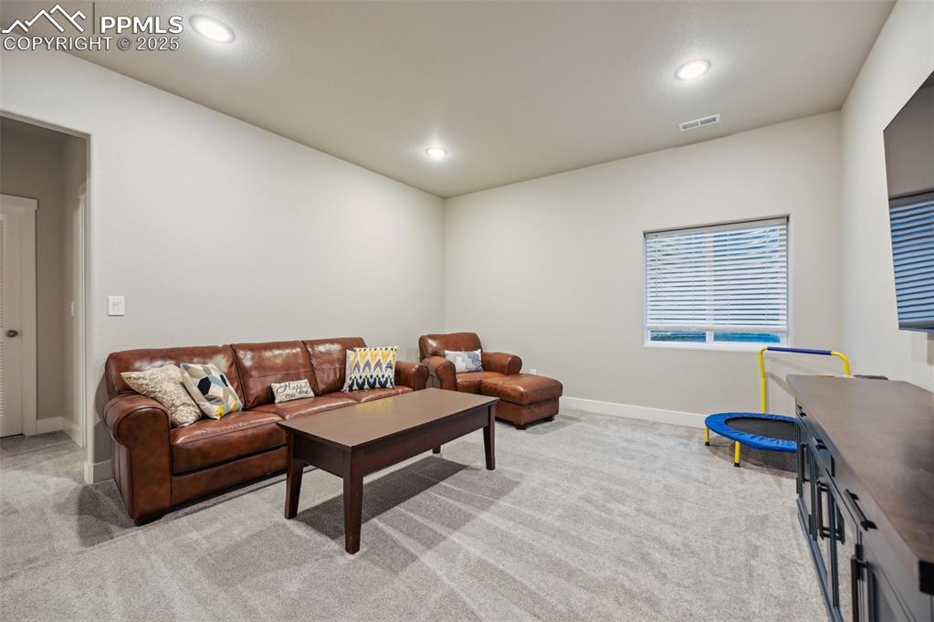 Image 35 of 46: Living area featuring light carpet and recessed lighting