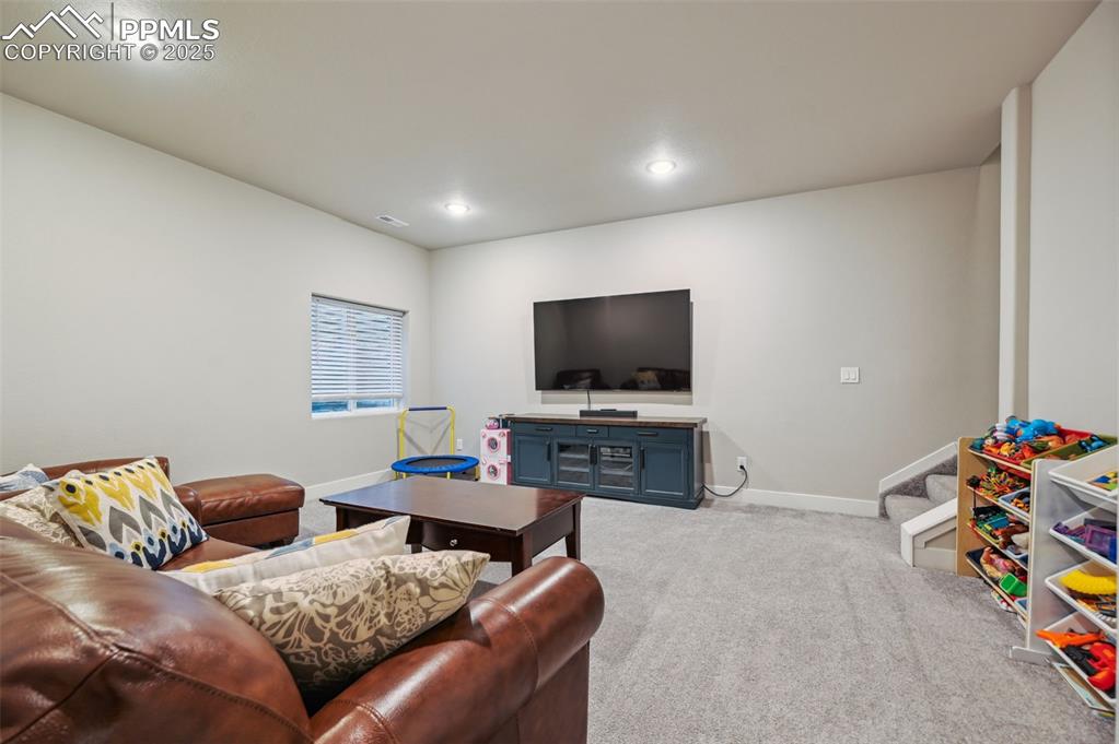 Image 36 of 46: Living room featuring light colored carpet and recessed lighting