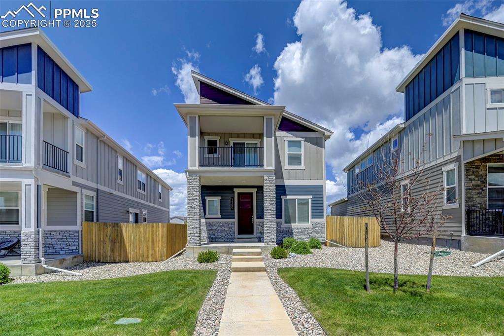 Image 39 of 46: Contemporary home with stone siding, board and batten siding, a balcony, an