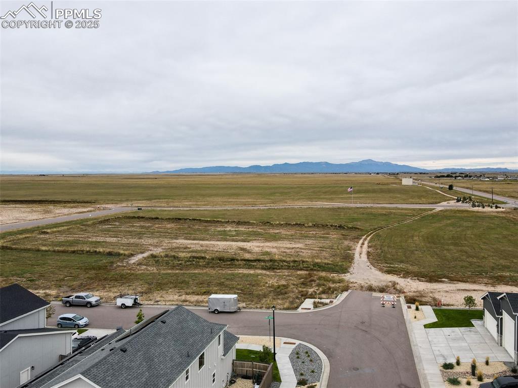 Image 11 of 50: Aerial view of sparsely populated area featuring a mountain backdrop