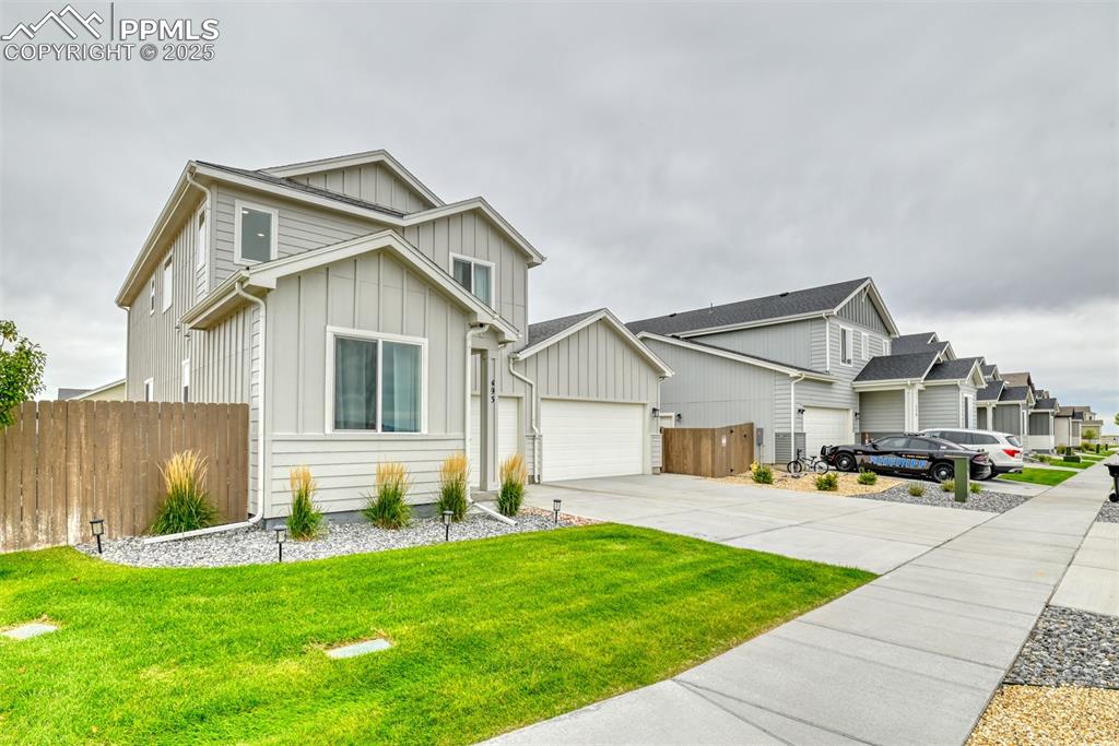 Image 23 of 50: View of front facade featuring board and batten siding, concrete driveway,
