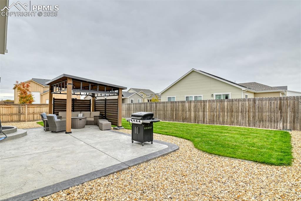 Image 25 of 50: Fenced backyard featuring an outdoor living space, a patio area, and area f