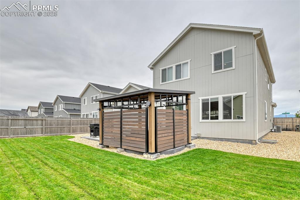 Image 27 of 50: Back of house featuring a fenced backyard