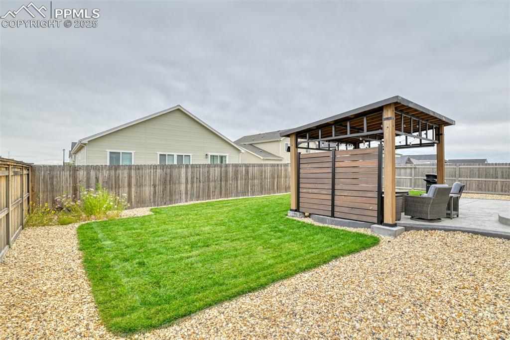 Image 28 of 50: Fenced backyard featuring a patio area