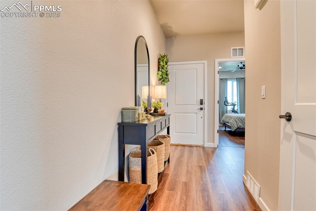 Image 30 of 50: Hallway with light wood-style flooring and a textured wall
