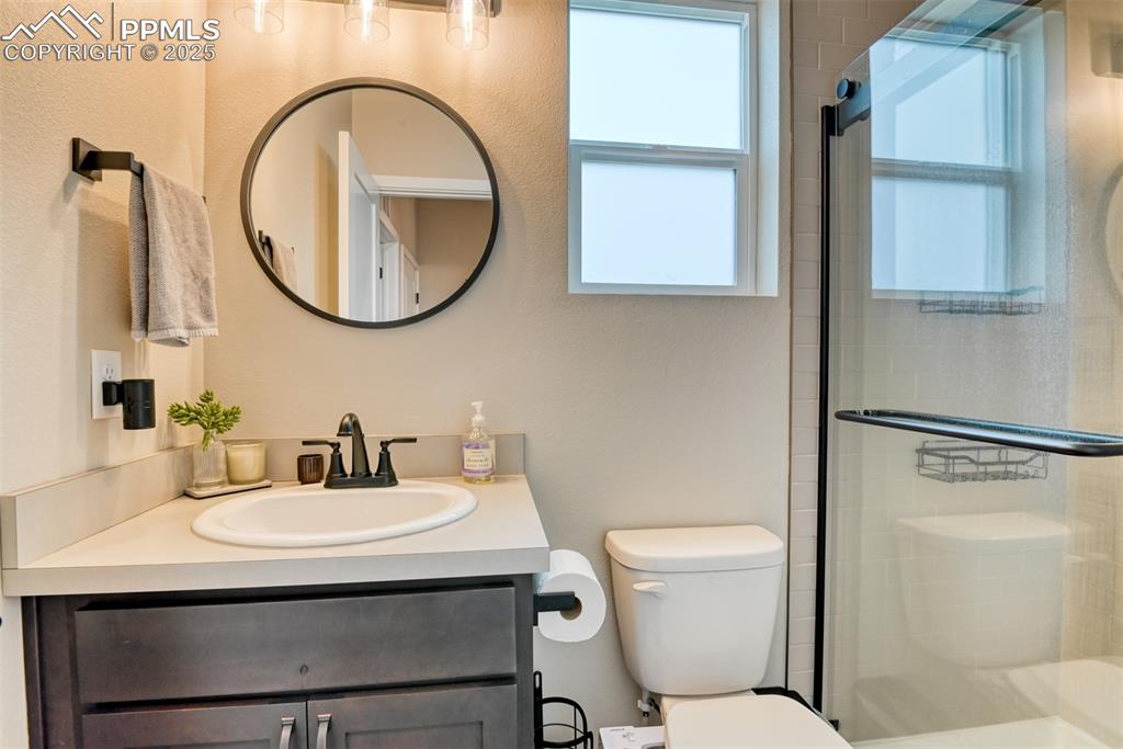 Image 35 of 50: Full bath with vanity, a shower stall, and a textured wall