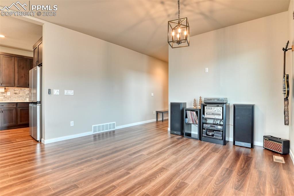 Image 39 of 50: Unfurnished dining area with light wood-style flooring and baseboards