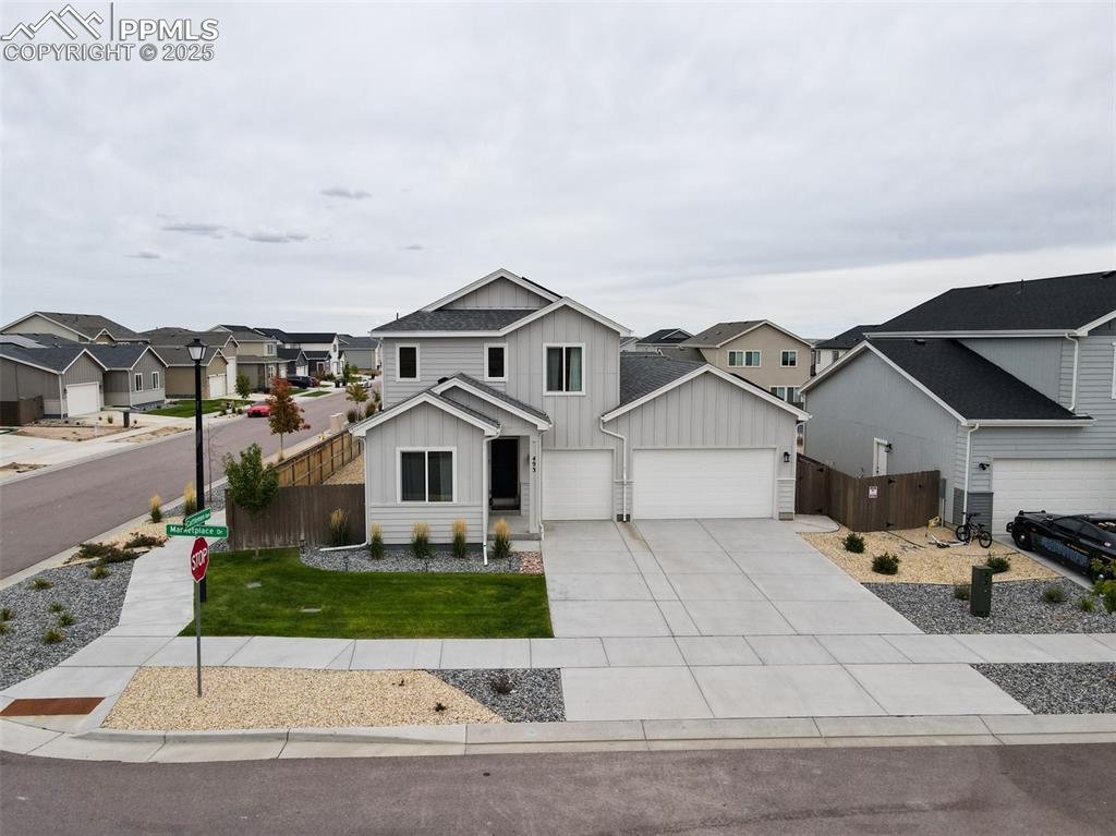 Image 4 of 50: View of front of house featuring board and batten siding, concrete driveway