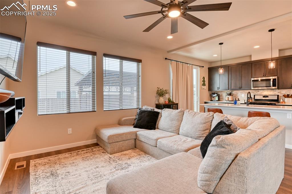 Image 42 of 50: Living room with wood finished floors, recessed lighting, and ceiling fan