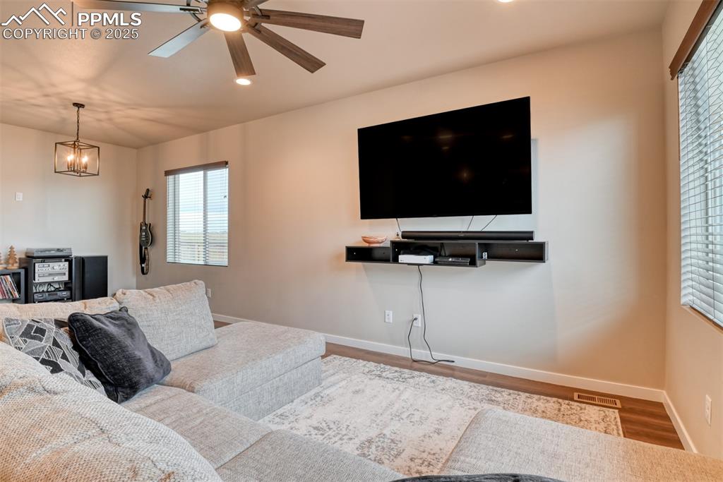Image 44 of 50: Living room with wood finished floors, ceiling fan, and recessed lighting