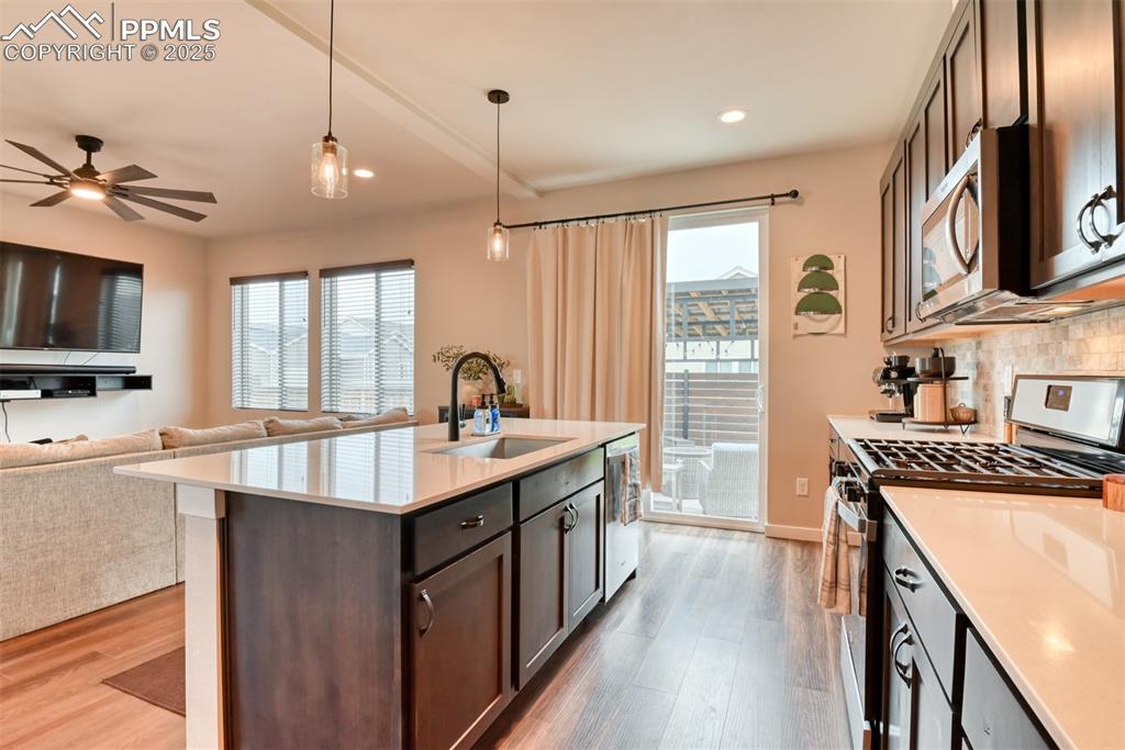 Image 47 of 50: Kitchen with appliances with stainless steel finishes, dark brown cabinets,