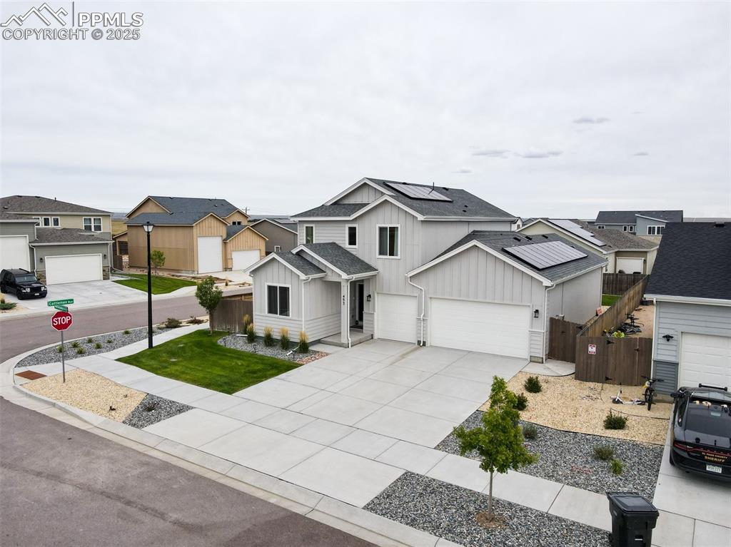 Image 5 of 50: View of front of property featuring board and batten siding, driveway, a ga
