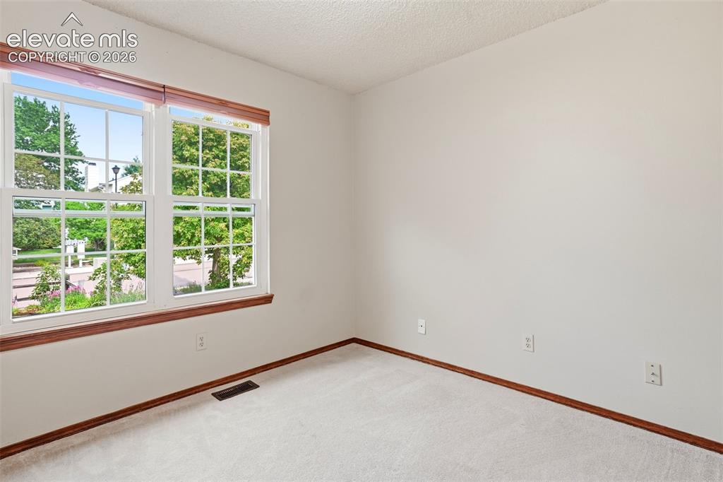 Image 31 of 49: Bedroom 2 overlooks the beautifully landscaped front yard