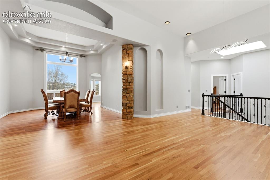 Image 13 of 46: Spacious open-concept interior featuring light wood-finish flooring, a ston