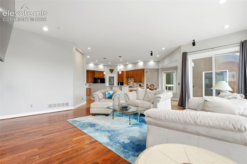 Image 17 of 46: Hardwood flooring, recessed lighting, and a sliding glass door
