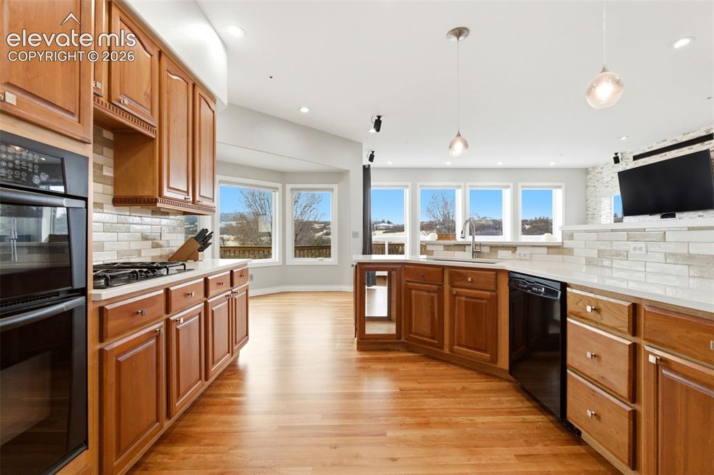 Image 18 of 46: Hardwood flooring throughout, wooden cabinetry, double wall oven, integrate