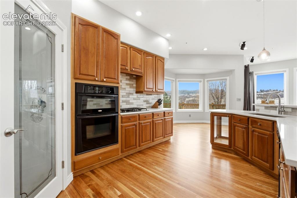 Image 20 of 46: Hardwood flooring, wood cabinetry, built-in double oven, paneled pantry doo