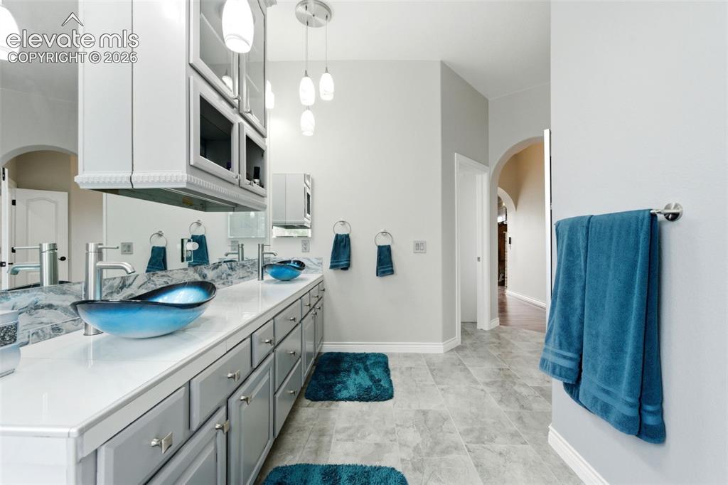 Image 24 of 46: Dual vessel sinks, expansive vanity with extensive cabinetry, overhead stor