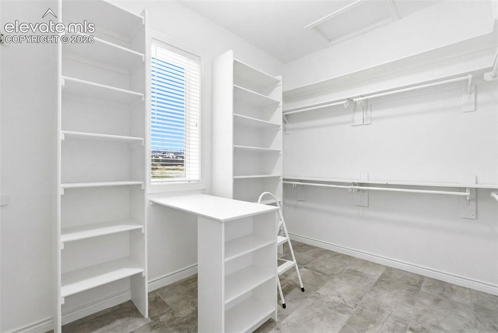Image 26 of 46: Built-in shelving units, integrated desk space, a window with blinds, cloth