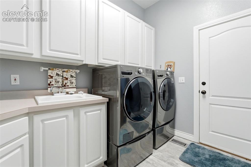 Image 27 of 46: White shaker-style cabinetry, a built-in sink with a countertop, and light-