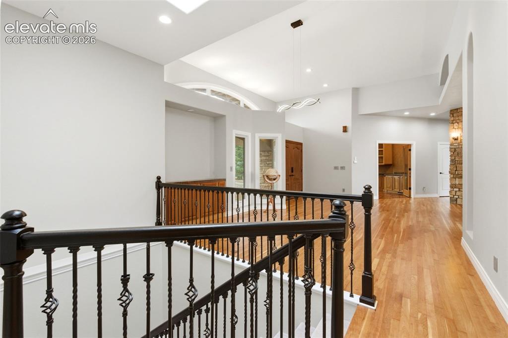 Image 30 of 46: Hardwood flooring, wrought iron railing, vaulted ceiling, recessed lighting