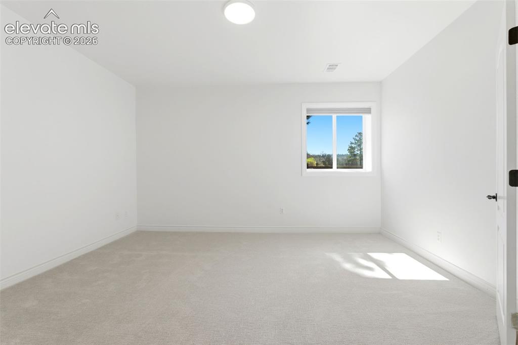 Image 38 of 46: Neutral paint palette with recessed lighting and a single window