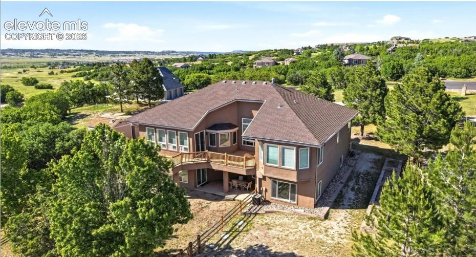 Image 42 of 46: Two-story residence with a multi-level deck, lower patio, and extensive win
