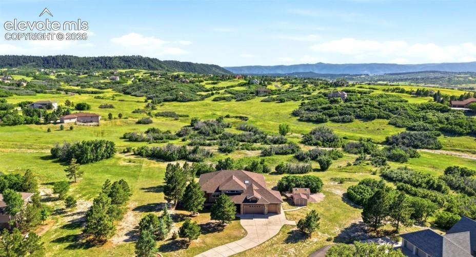 Image 46 of 46: Expansive residential property featuring a paved driveway, natural landscap