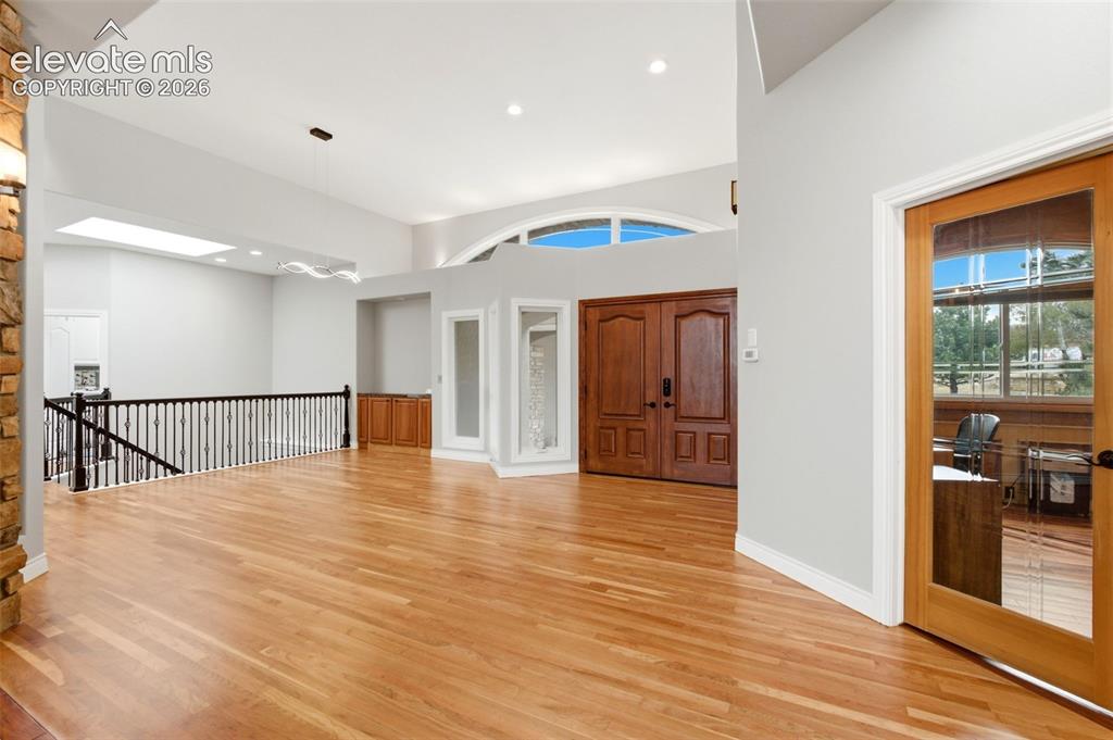 Image 8 of 46: High ceilings, wood-finish flooring, double entry doors, an arched window, 