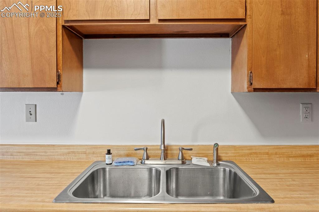 Image 19 of 50: Kitchen view of light countertops and brown cabinets