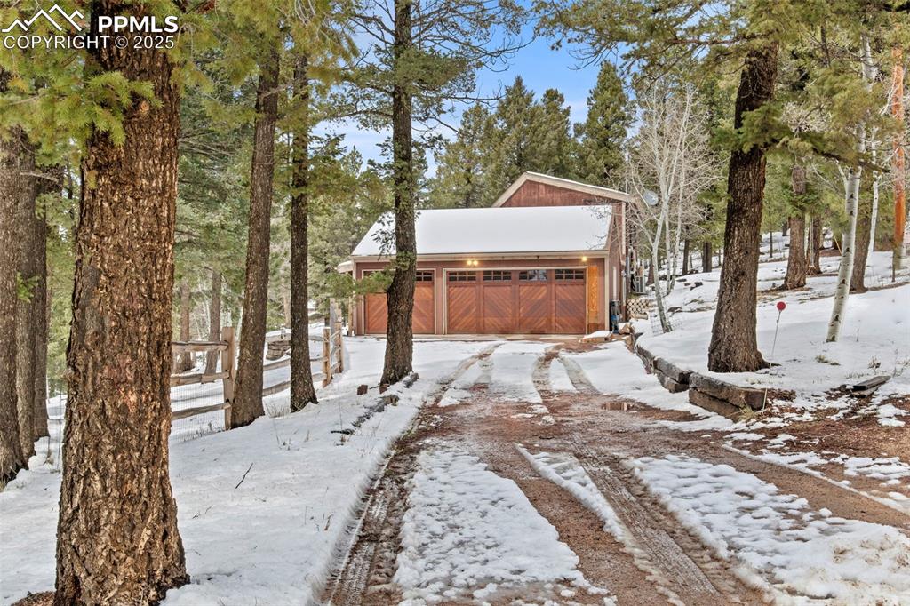 Image 3 of 50: Yard layered in snow featuring a garage and an outdoor structure