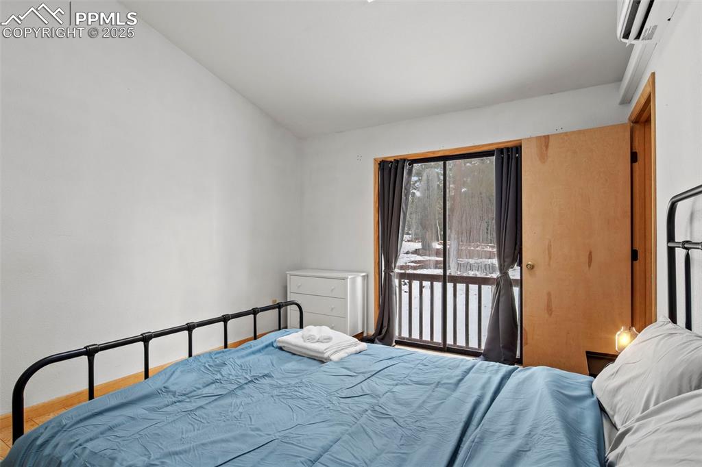 Image 36 of 50: Bedroom with access to outside and an AC wall unit