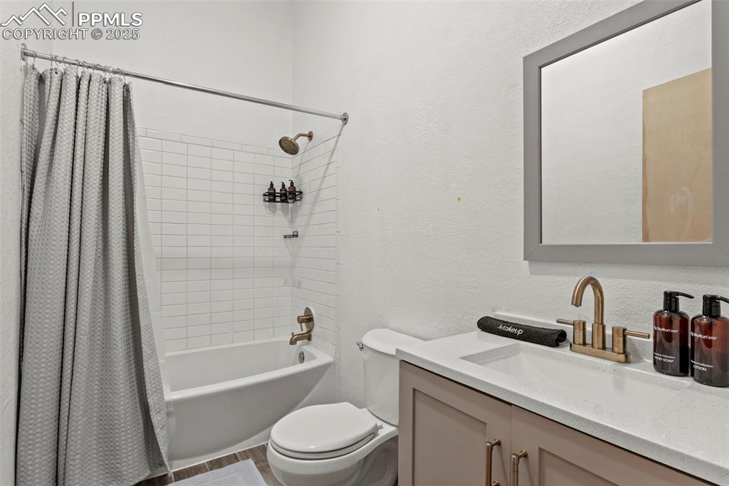 Image 38 of 50: Bathroom with a textured wall, shower / bath combo with shower curtain, van