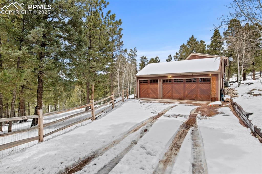 Image 4 of 50: Yard covered in snow with an outbuilding and a detached garage