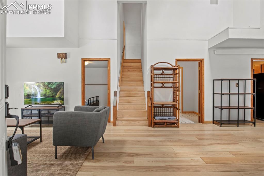 Image 7 of 50: Stairway with wood finished floors and a towering ceiling