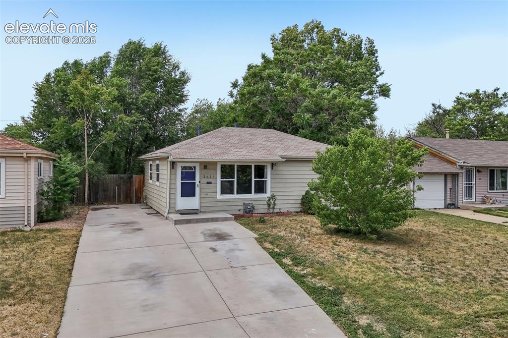 Image 27 of 34: Ranch-style residence featuring light-colored siding, a concrete driveway, 