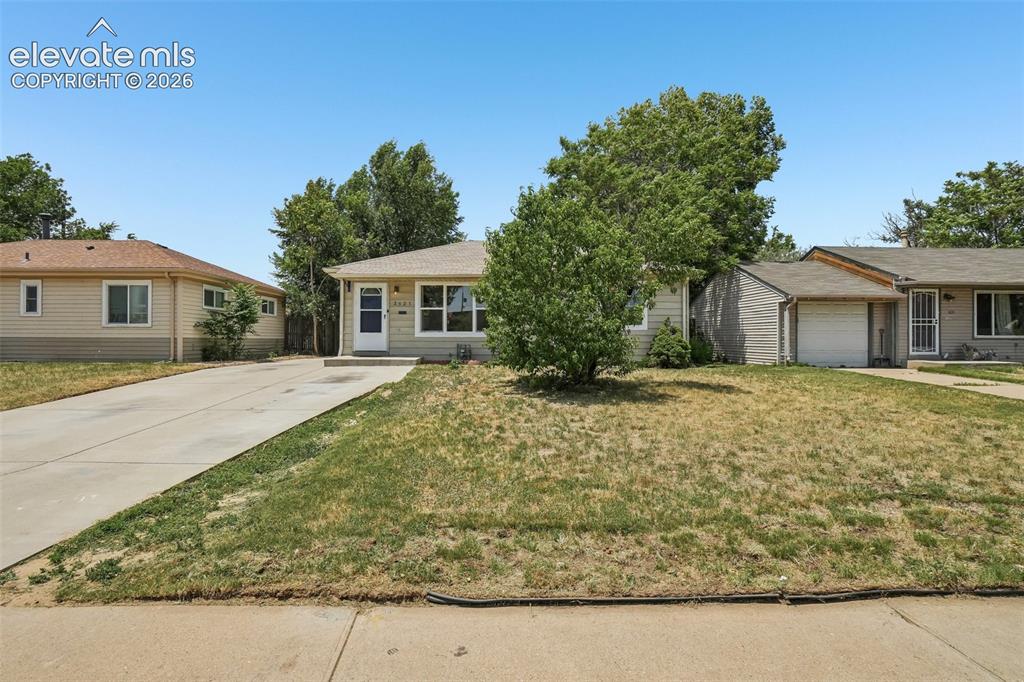 Image 4 of 34: Single-story residence with a concrete driveway, front entry with storm doo
