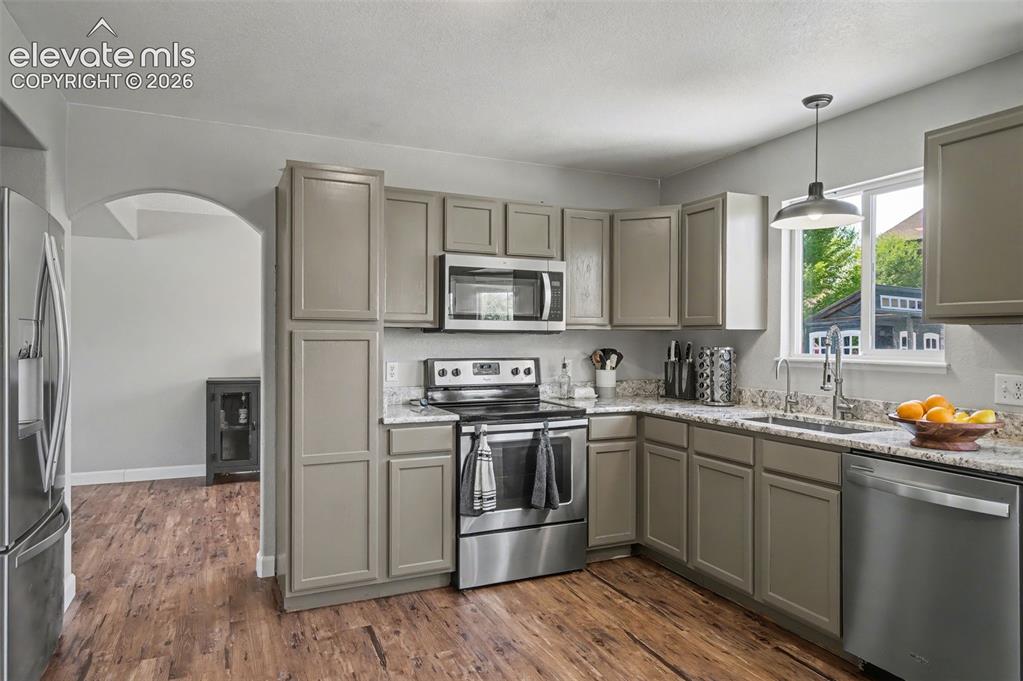 Image 10 of 37: Kitchen featuring wood-finish flooring, light-colored cabinetry, stainless