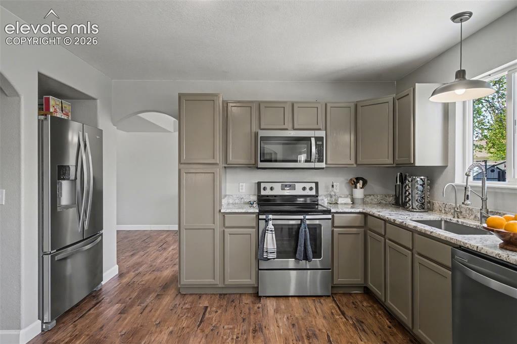 Image 11 of 37: Kitchen featuring wood-finish flooring, light grey cabinetry, stainless ste