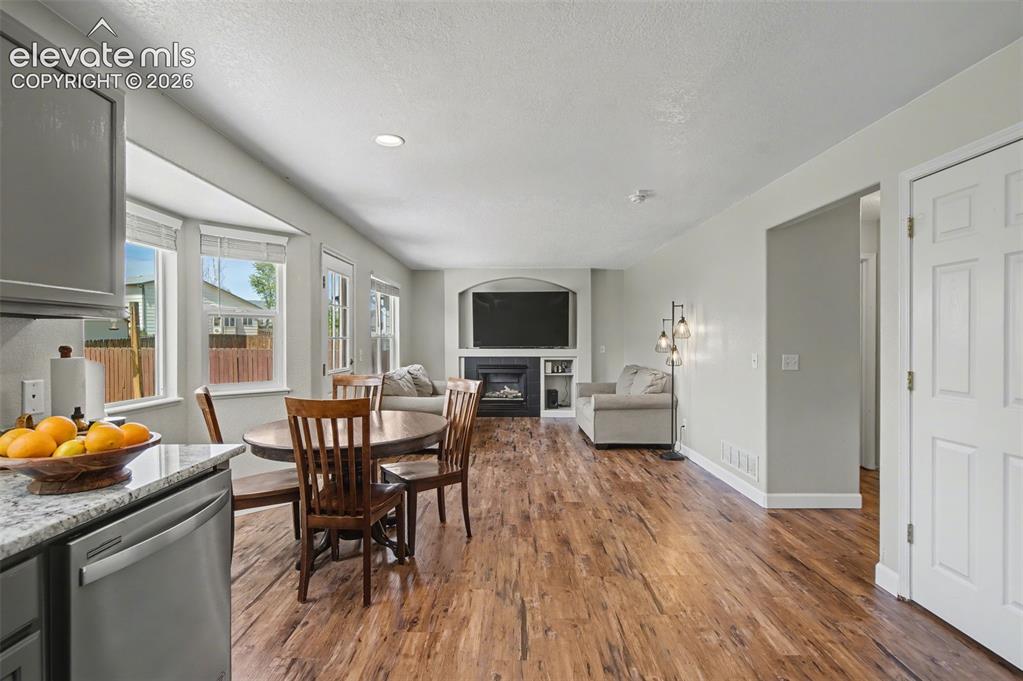 Image 14 of 37: Open-concept living area featuring wood-finish flooring, a bay window with 