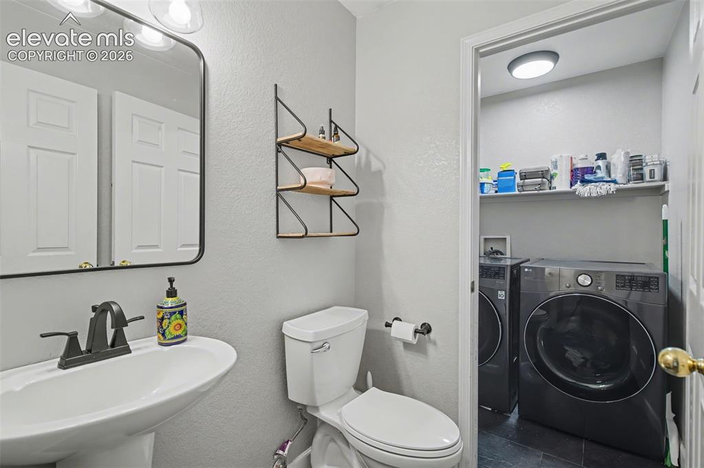 Image 15 of 37: Pedestal sink with a matte black faucet, wall-mounted mirror, and integrate