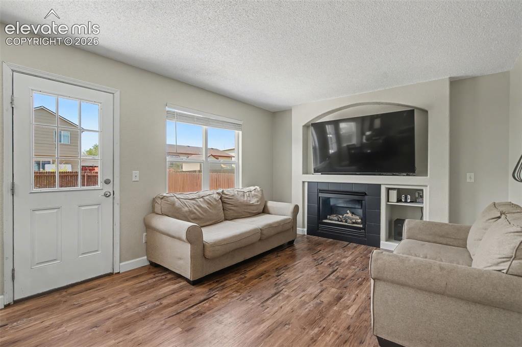 Image 18 of 37: Living space featuring wood-finish flooring, a built-in entertainment cente