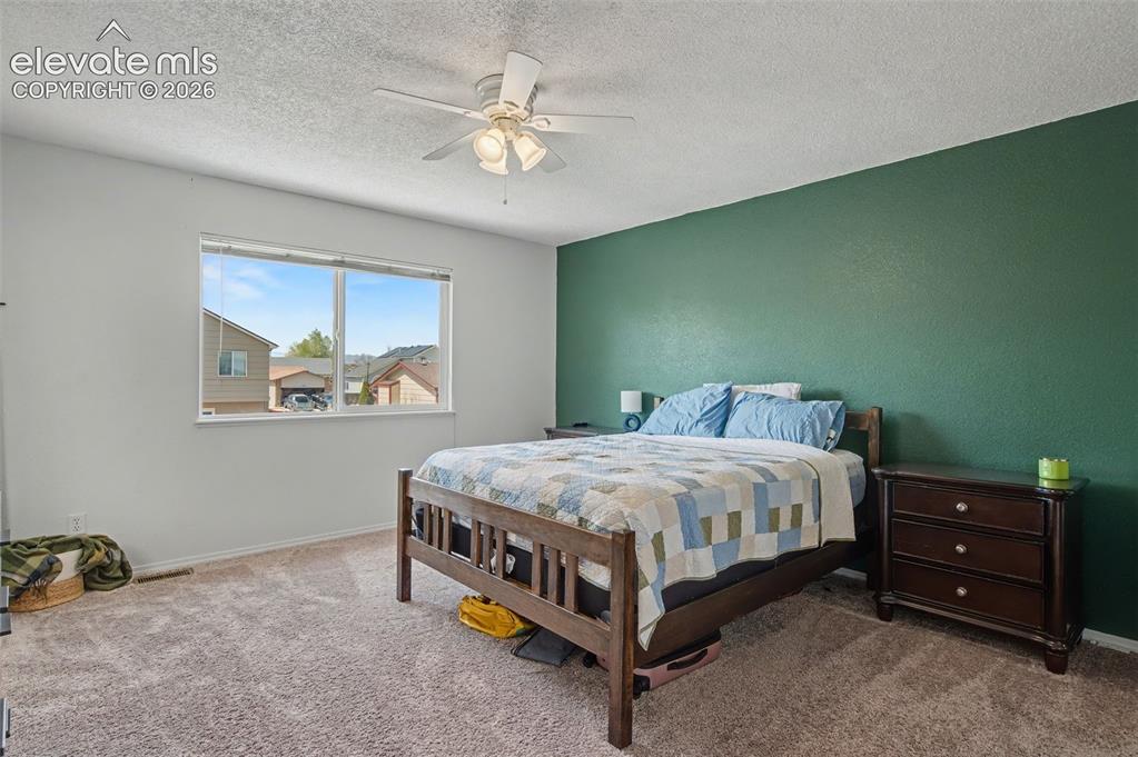 Image 20 of 37: Comfortable bedroom featuring a large window, neutral wall tones, a texture