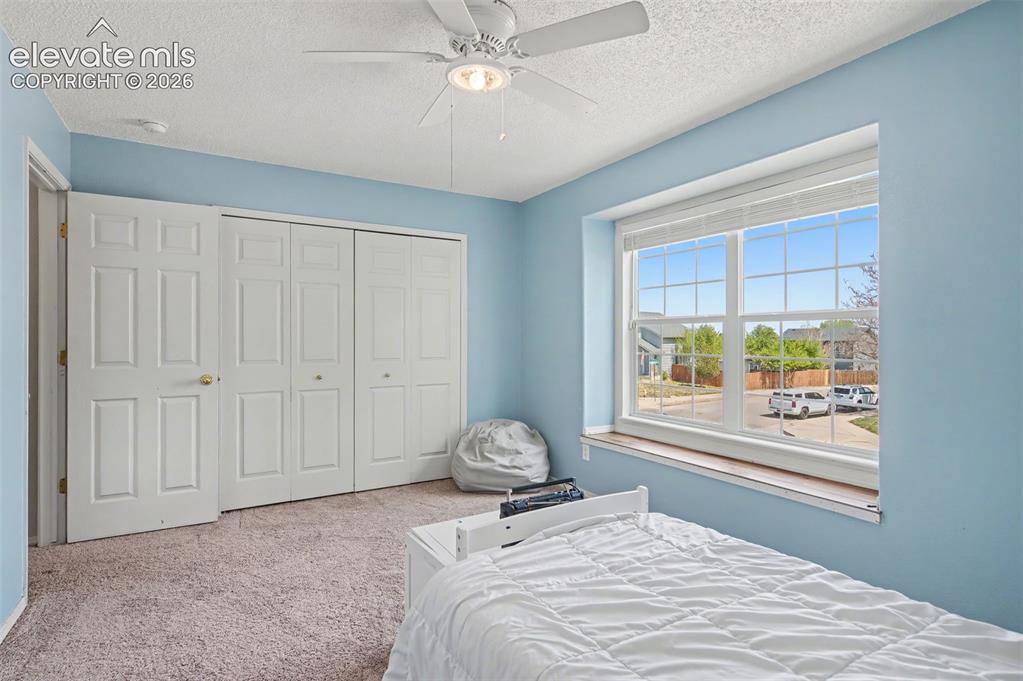 Image 26 of 37: Bright room featuring a large window, ceiling fan with integrated lighting,