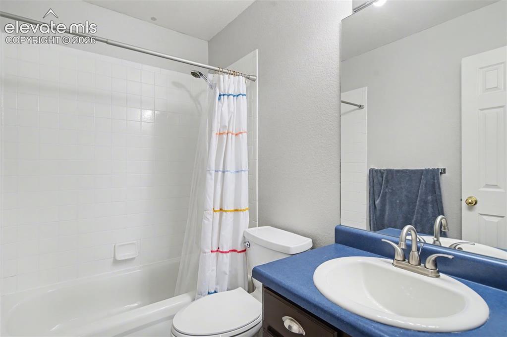 Image 27 of 37: Bathroom featuring a white tub and shower combination with tile surround, a