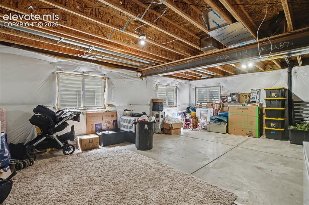 Image 31 of 37: Unfinished basement space featuring exposed wood joists and a steel support