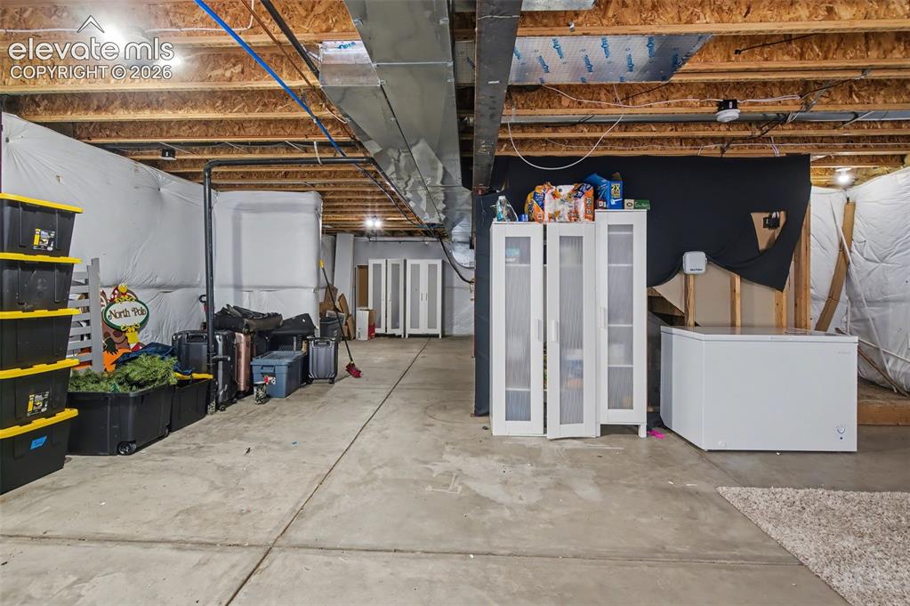Image 32 of 37: Unfinished basement offering substantial floor area with exposed ceiling jo