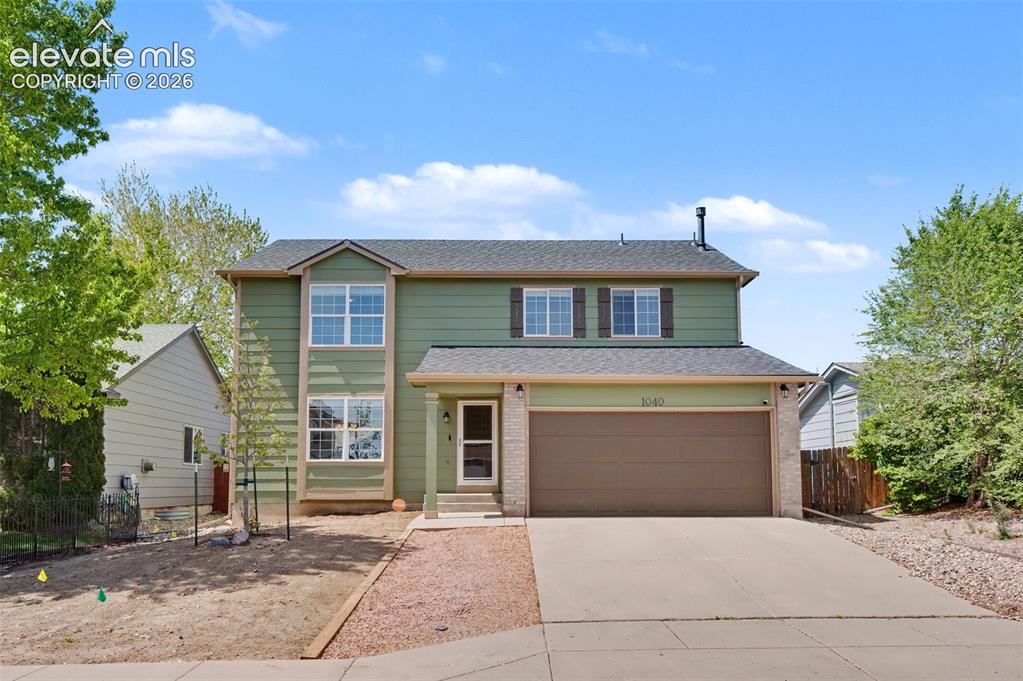 Image 4 of 37: Two-story residence featuring a two-car garage, stone veneer accents, and a