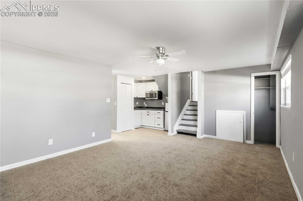 Image 15 of 42: Garden level living room with kitchenette and a bedroom.