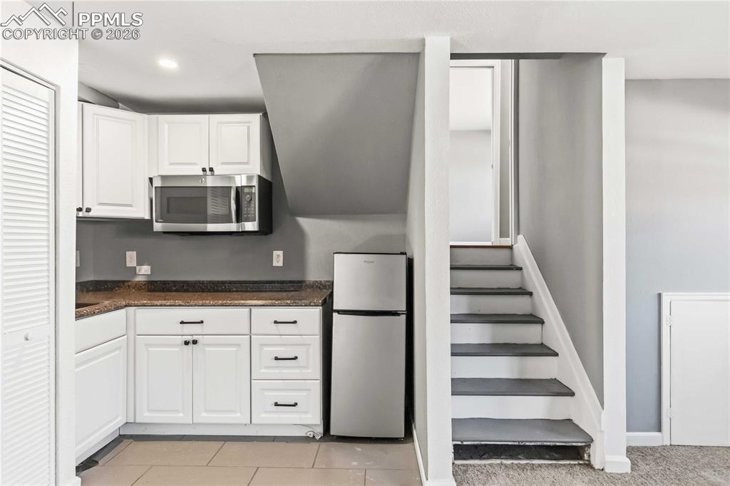 Image 16 of 42: Garden level basement kitchenette. Little fridge pictured here is not an in